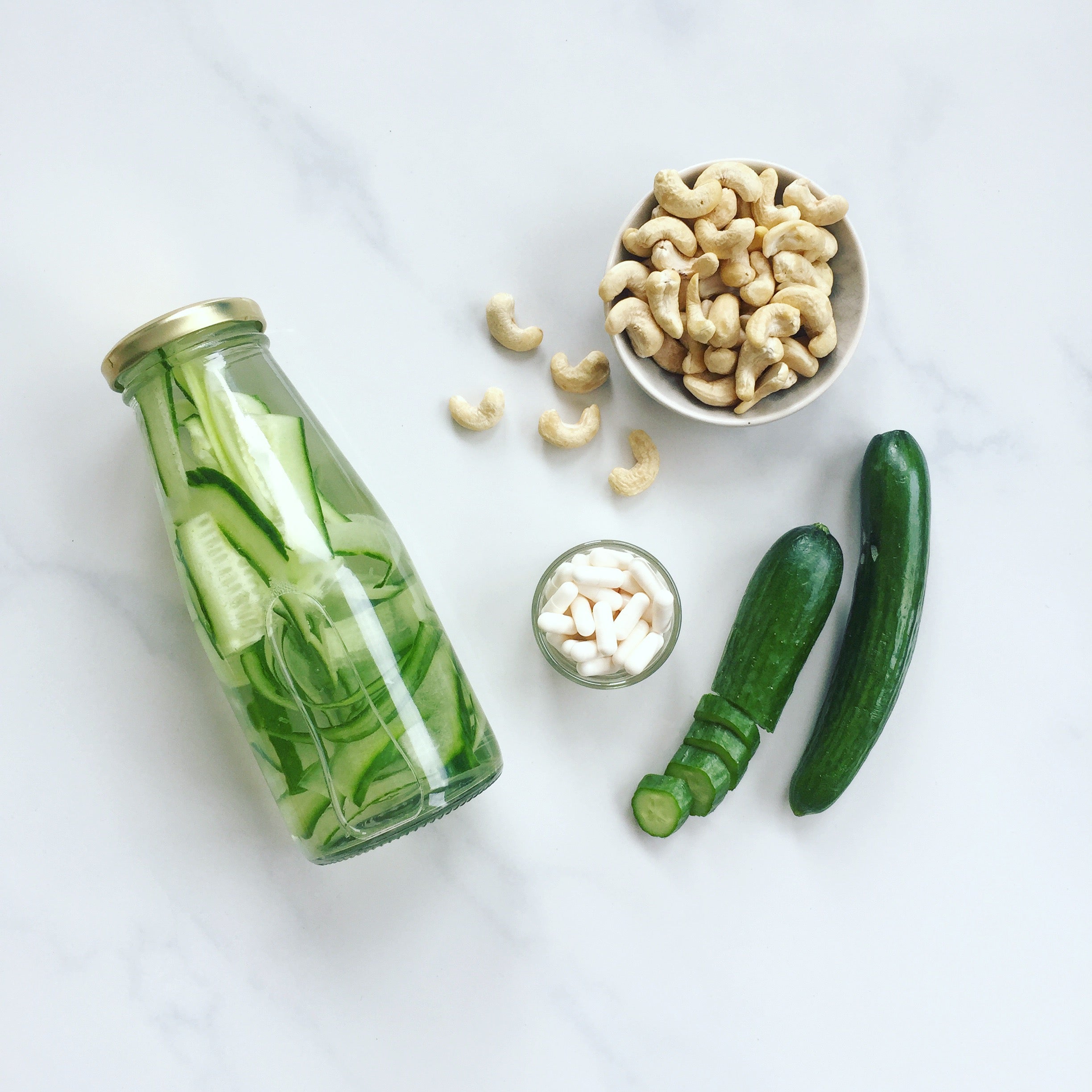 vand med agurk, kosttilskud og cashewnødder
