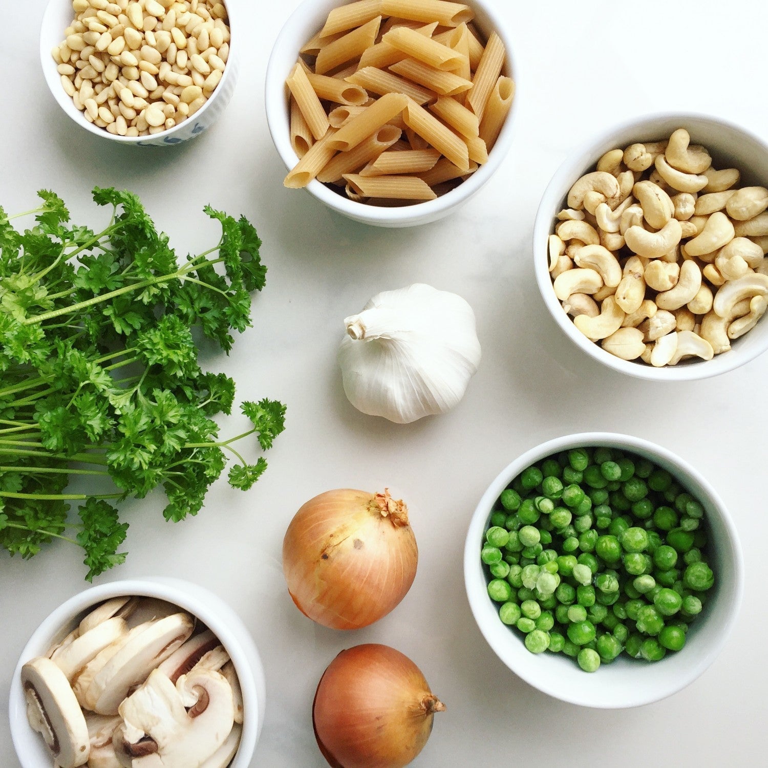 skåle med pasta cashewnødder ærter persille champignon hvidløg 