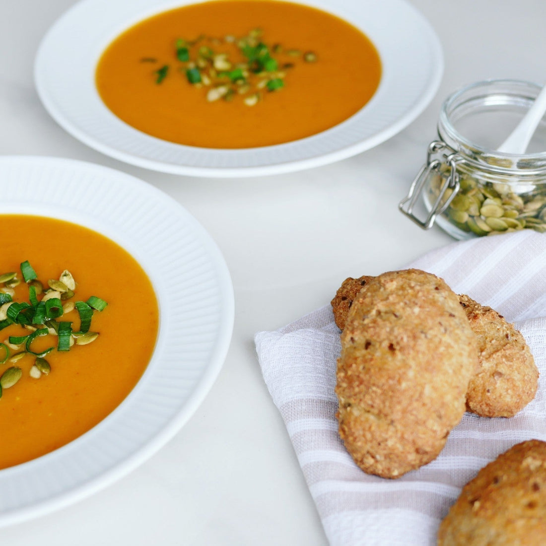 skåle med orange suppe og brød