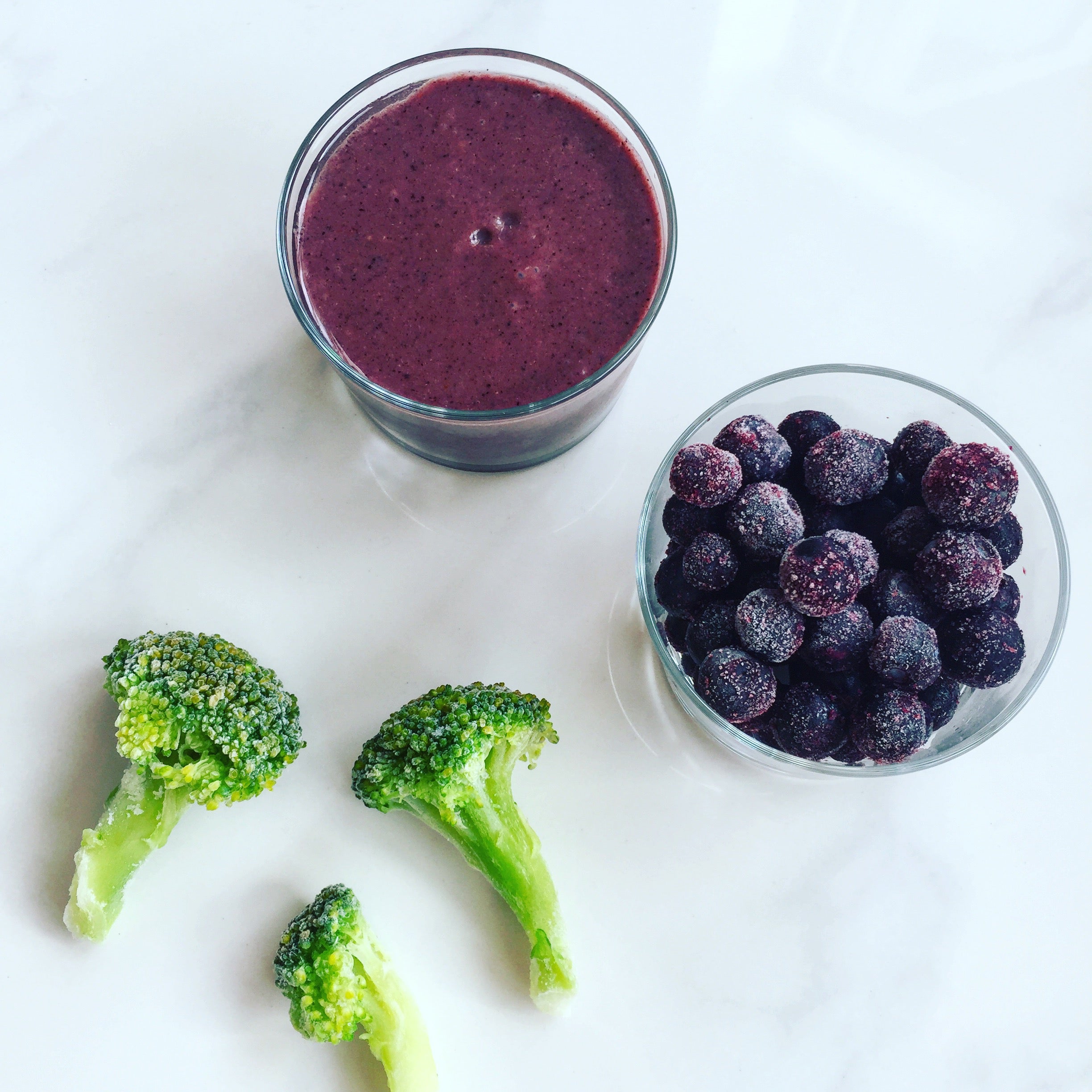 broccoli og blåbær samt et glas med en lille smoothie