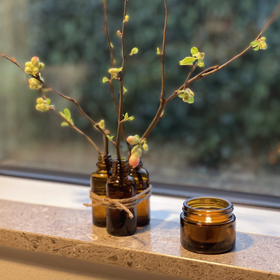 Genbrugsglas med blomster og lys