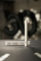 Naturligolie vippeserum i hvid emballage og æske på grå baggrund.