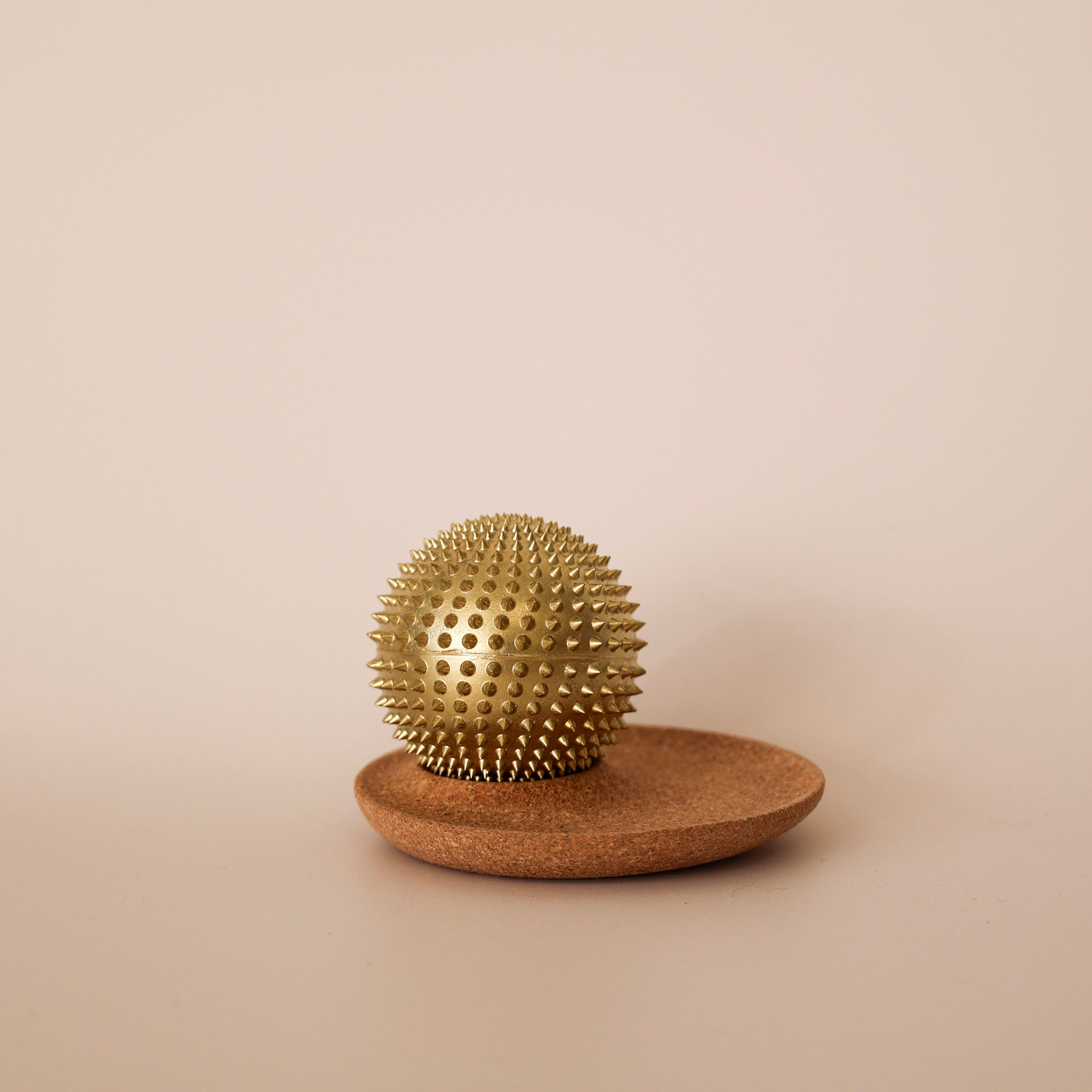 Gylden Shakti Wonderball akupressurbold på korkplade